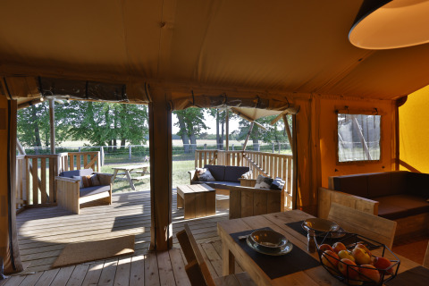 Intérieur d’une tente safari glamping avec meubles en bois et terrasse chez Frei wie der Wind, Baltique.
