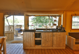 Hyggeligt glamping-køkken i safaritelte hos Frei wie der Wind ved Østersøen med udendørs træterrasse.