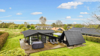 Modernes 6-Personen-Ferienhaus in Hemmet mit Holzterrasse, Liegestühlen und gepflegtem Garten.