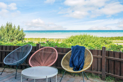 Terrace with colorful chairs and sea view from the 4 person holiday home in Glesborg, Denmark.
