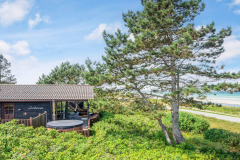 Casa vacanze a Glesborg, Danimarca, con jacuzzi esterna, circondata da alberi e vista sulla spiaggia.