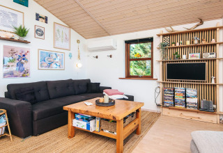 Salon lumineux du «4 person holiday home in Glesborg», Danemark, avec canapé foncé, table et étagères.