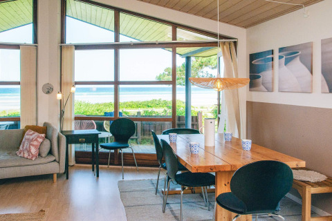 Lichte woon- en eetruimte in een vakantiehuis in Glesborg, Denemarken, met zicht op zee.
