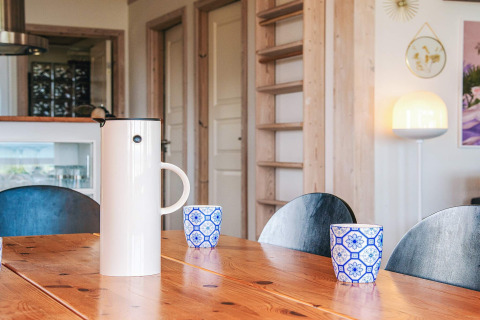 Modern dining table scene with coffee pot and blue-white cups in a holiday home in Glesborg, Denmark.