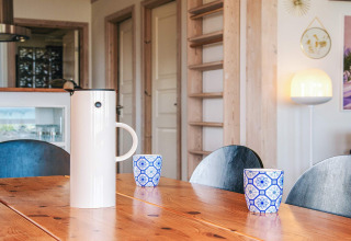 Mesa de comedor moderna con cafetera y tazas azul-blanco en casa de vacaciones en Glesborg, Dinamarca.