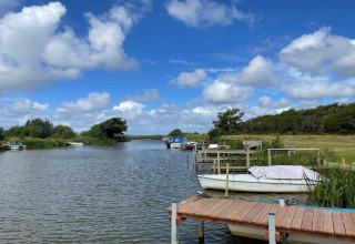 Rivière paisible avec bateaux près du gîte 6 personnes à Hemmet, Danemark, sous ciel bleu.