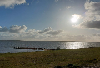 Udsigt over en sø og vindskyer ved solnedgang fra 6 personers feriehus i Hemmet, Danmark.