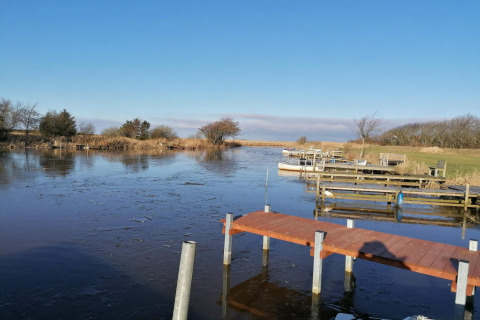 Uitzicht op een bevroren meer met steigers en boten bij het 6-persoons vakantiehuis in Hemmet, Denemarken.