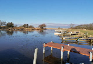 Uitzicht op een bevroren meer met steigers en boten bij het 6-persoons vakantiehuis in Hemmet, Denemarken.