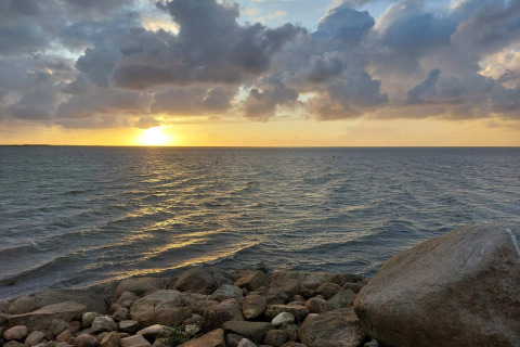 Sonnenuntergang am Meer mit dramatischen Wolken und Steinen, gesehen bei 6-Personen-Ferienhaus in Hemmet, Dänemark.