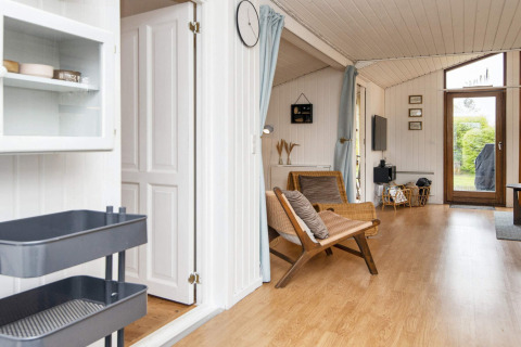 Lichte leefruimte in vakantiehuis in Hemmet, Denemarken, met houten vloer en zicht op tuin.