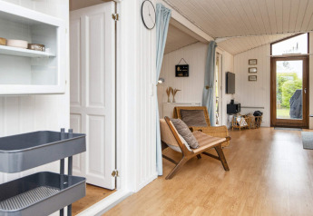 Heller Wohnraum in einem Ferienhaus in Hemmet, Dänemark, mit Holzfußboden und Gartenblick.