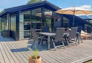 Terrasse d'une maison de vacances pour 6 personnes à Hemmet, Danemark, avec table et parasol.