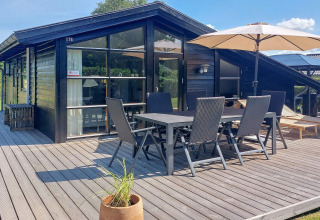 Terrasse d'une maison de vacances pour 6 personnes à Hemmet, Danemark, avec table et parasol.