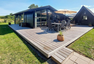 Terrasse extérieure d'une maison de vacances pour 6 personnes à Hemmet, Danemark, avec mobilier et parasol.