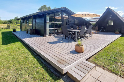 Buitenterras aan een vakantiehuis voor 6 personen in Hemmet, Denemarken, met tuinset en parasol.