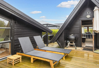 Buitenterras van 6-persoons vakantiehuis in Hemmet, Denemarken, met ligbedden en barbecue op het terras.