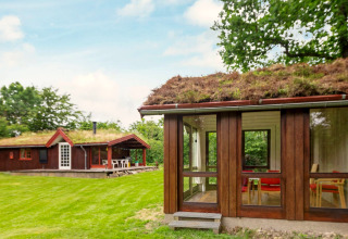 Vue sur un chalet avec toit végétalisé du lodge pour 6 personnes à Roslev, Danemark, entouré de verdure.