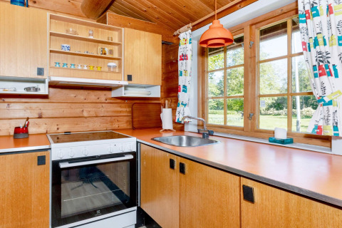 Küche mit Holzverkleidung und bunten Vorhängen im Ferienhaus '6 person holiday home in Roslev', Dänemark.