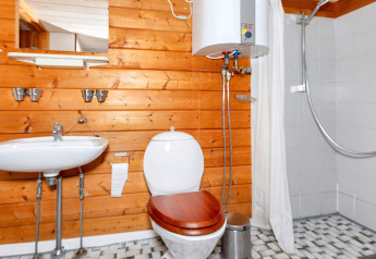 Badkamer in een houten vakantiewoning in Roslev, Denemarken, met toilet, wastafel en douche.