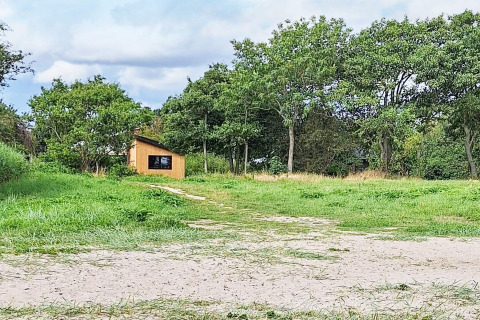 Vista de una pequeña cabaña entre árboles en el 5 estrellas casa de vacaciones en Sydals, Dinamarca.