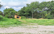 Zicht op een klein houten huis in het groen bij een 5-sterren vakantiewoning in Sydals, Denemarken.