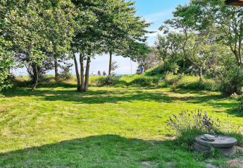 Groene tuin met bomen en zon bij de lodge '5 star holiday home in Sydals', Denemarken.