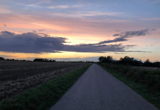 Zonsondergang boven een landelijke weg bij het 5-sterren vakantiehuis in Sydals, Denemarken, met velden.