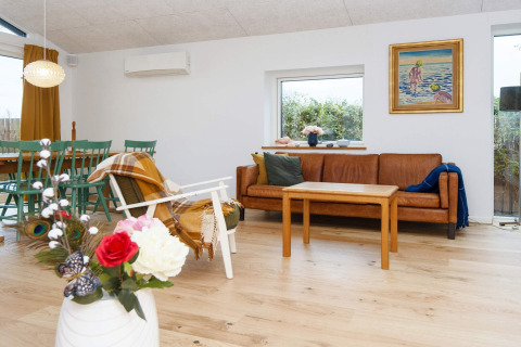 Moderne woonkamer in een vijfsterren vakantiehuis in Sydals, Denemarken, met bank en bloemen.