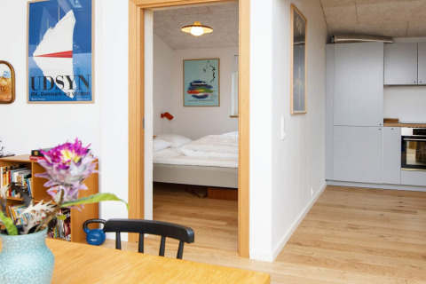 Uitzicht op slaapkamer en keuken in een vakantiewoning in Sydals, Denemarken, met moderne stijl en kleurrijke posters.