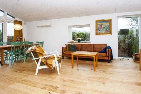 Woonkamer van 5-sterren vakantiehuis in Sydals, Denemarken, met lederen zetel en eetruimte.