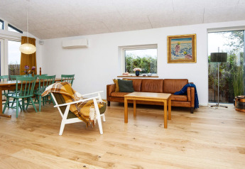 Living room of 5 star holiday home in Sydals, Denmark, with leather sofa, dining area, and large windows.