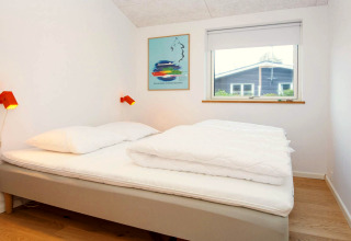 Chambre moderne d'une maison de vacances 5 étoiles à Sydals, Danemark, avec lit double et fenêtre.