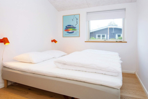 Moderne slaapkamer in een 5-sterren vakantiehuis in Sydals, Denemarken, met tweepersoonsbed en raam.
