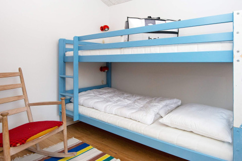 Knusse kamer in vijfsterren vakantiehuis in Sydals, Denemarken, met blauwe stapelbed en schommelstoel.