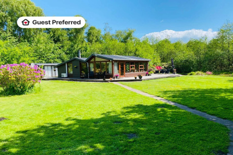 6-persoons vakantiehuis in Bogense met uitgestrekt groen gazon, zonnig terras en bloemen rondom.