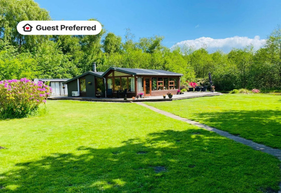 6-persoons vakantiehuis in Bogense met uitgestrekt groen gazon, zonnig terras en bloemen rondom.
