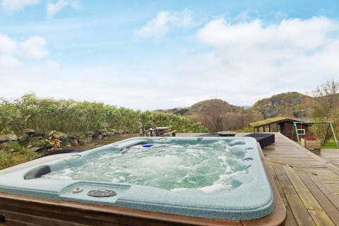 Bubbelbad buiten op houten terras met uitzicht, bij 12-persoons vakantiehuis in Tau, Denemarken.