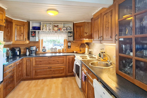 Cucina accogliente con mobili in legno e elettrodomestici moderni, nella casa vacanze 12 persone a Tau, Danimarca.