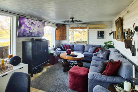 Gezellige woonkamer in een vakantiehuis in Tau met grote hoekbank, tv en uitzicht op het terras.