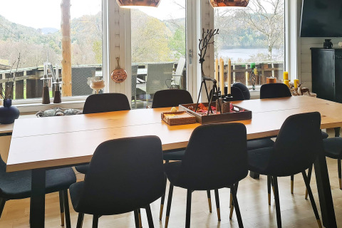 Spisebord med otte sorte stole i ferieboligen '12 person holiday home in Tau' med udsigt over natur i Danmark.