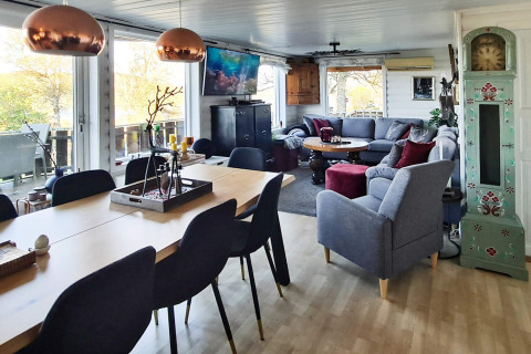 Ruime lodge woonkamer met eettafel, gezellige banken, grote ramen en Scandinavisch interieur.
