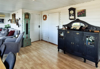 Soggiorno accogliente nella casa vacanze per 12 persone a Tau, Danimarca, con mobili classici antichi.