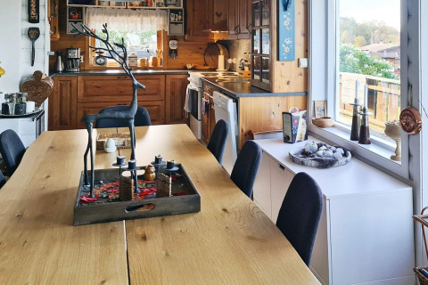 Accogliente zona pranzo e cucina in una casa vacanze per 12 persone a Tau, Danimarca, con legno.