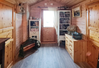 Gezellige houten gang met boekenkasten en ladekast in 12-persoons vakantiehuis in Tau, Denemarken.