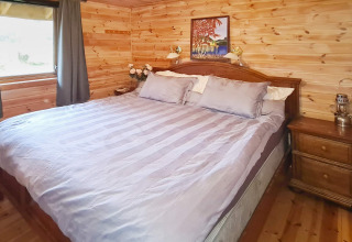 Camera da letto nella 'Casa vacanze per 12 persone a Tau' in Danimarca, con pareti in legno e letto grande.