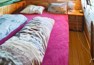 Slaapkamer in een 12-persoons vakantiehuis te Tau, Denemarken, met dubbel bed en nachtkastje.