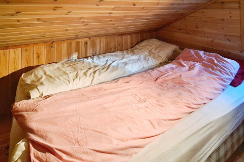 Zwei Einzelbetten in einem gemütlichen Dachzimmer mit Holzverkleidung im 12-Personen-Ferienhaus in Tau.