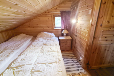 Slaapkamer met houten wanden in het 12-persoons vakantiehuis in Tau, Denemarken, met twee bedden.