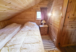 Slaapkamer met houten panelen in het 12-persoons vakantiehuis te Tau, Denemarken, met twee bedden.